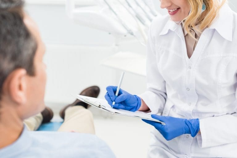 Dentist taking notes for dental patient